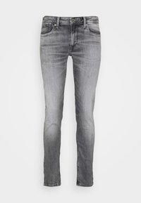Grå denimjeans med smal passform, fem fickor, lätt slitningar och sömnadsdetaljer. Ren fåll och standard knappstängning.