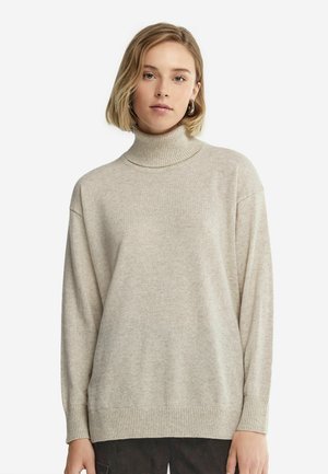 Beige rullekrave sweater lavet af blødt, tekstureret materiale. Har lange ærmer, ribbede manchetter og en afslappet pasform med minimal detaljering.