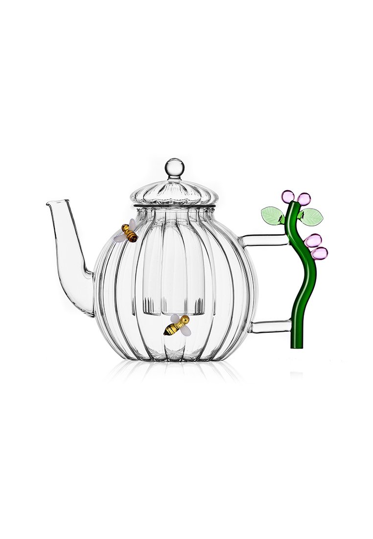 Heldere glazen theepot met verticale ribbels, groene handvat in de vorm van een plant, decoratieve paarse en groene accenten, en twee kleine bijfiguren.