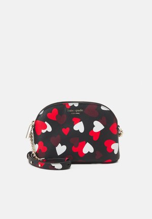 Svart syntetisk crossbody-väsk med flerfärgade hjärtmönster i rött, vitt och vinröd. Har en logotyp i guldton och kedjade accenter.