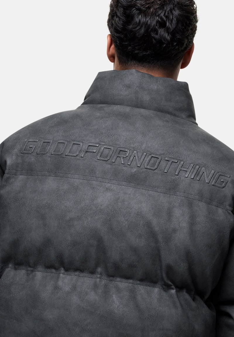 Graue gepolsterte Jacke mit hohem Kragen, aus einem strukturierten Material gefertigt. Auf der Rückseite befindet sich ein geprägter Schriftzug "GOODFORNOTHING".
