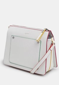 Bolso de cuero blanco con acentos de color en verde, amarillo y rojo. Presenta una forma estructurada, correa desmontable y un bolsillo en la parte frontal.