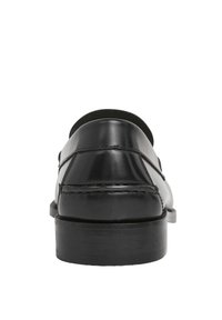 Crne kožne mokasine s glatkom završnom obradom, zaobljenim vrhom i ravnim, teksturiranim potplatom. Sadrže šavove duž strane.