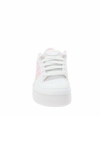 Sneaker bianca con accenti rosa, caratterizzata da una tomaia in rete, punta rotonda, suola piatta bianca e il classico design a tre strisce sui lati.
