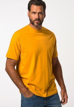 Short-sleeve, round-neck yellow T-shirt in a smooth cotton blend; paired with blue denim jeans, highlighting a casual fit.