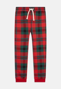 Rode geruite joggingbroek met groene en zwarte accenten. Elastische tailleband met een witte trekkoord. Opgerolde enkels in effen rood. Zachte stofstructuur.