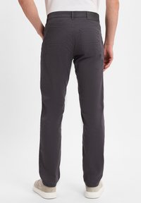 Grijze, rechte broek van duurzaam materiaal. Beschikt over twee achterzakken en een subtiel merkembleem op de tailleband. Draagt bij lichte schoenen.