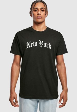 Melns kokvilnas T-krekls ar baltu Gotikas stilā uzrakstītu "New York". Īsas piedurknes, apaļa izgriezne un brīvi pieguļoša forma.