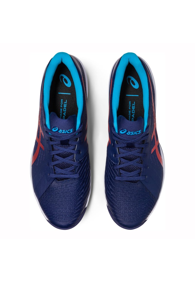 Scarpe sportive navy e turchesi con tomaia testurizzata, caratterizzate da accenti rossi e una suola resistente, progettate per gli sport di padel.