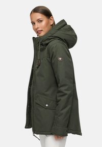 Green insulated jacket with a hood, featuring a zippered front, two side pockets, and a circular logo patch on the left arm.