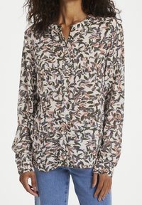 Blusa a maniche lunghe con motivo a foglie nei toni del verde, rosa e blu. Presenta una chiusura con bottoni davanti e un collo rotondo, realizzata in un tessuto leggero.