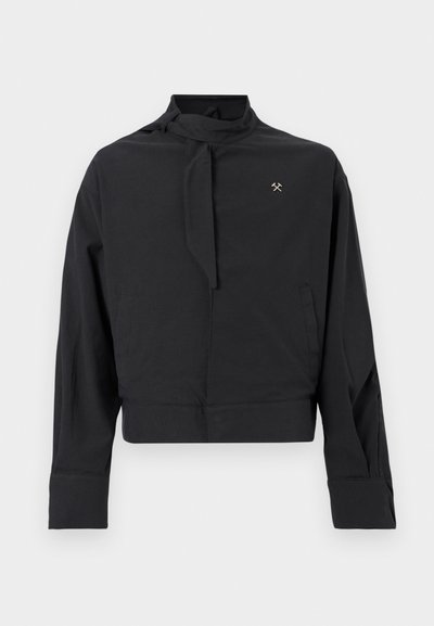 Μαύρο μπουφάν με μακριά μανίκια, λεπτομέρεια με δετή ψηλή λαιμόκοψη, δύο πλαϊνές τσέπες, μανσέτες στα μανίκια και μικρό λογότυπο με σταυρωμένα σφυριά στο στήθος.