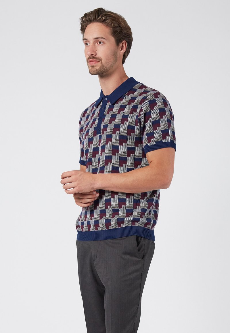 Gestreiftes Poloshirt in Marineblau, Rot und Grau mit geometrischem Muster, ausgestattet mit einem Kragen, kurzen Ärmeln und einem gerippten Saum.