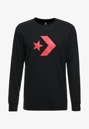 T-shirt noir à manches longues en tissu texturé, avec un grand logo étoile rouge et flèche sur le devant. Encolure ronde et coupe standard.