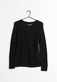 Pull noir tricoté à manches longues avec col ras du cou, suspendu à un cintre noir sur un fond blanc.