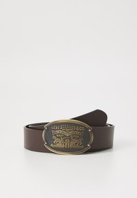 Brown leather belt featuring a gold-toned oval buckle with embossed text and imagery, including two horses and design elements.