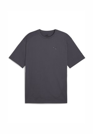 Camiseta gris de manga corta hecha de tela suave. Presenta un cuello redondo, mangas raglán y un pequeño logo reflectante en el pecho.