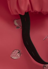 Rosa silikonväska med dragsko, svart rem och tryckta fruktdesigner, inklusive jordgubbar och persikor.