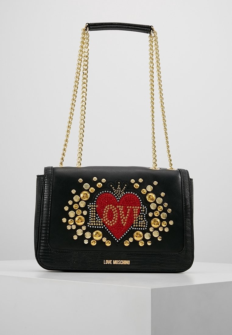 Svart Love Moschino-handväska med guldkedjesnor, röd hjärtform och guldnitar som stavar "LOVE" på framsidan.