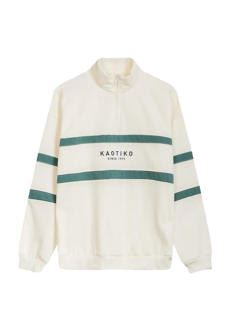 Sudadera crema de media cremallera con rayas turquesa y el texto "KAOTIKO desde 1999" en el frente; textura suave, corte relajado.