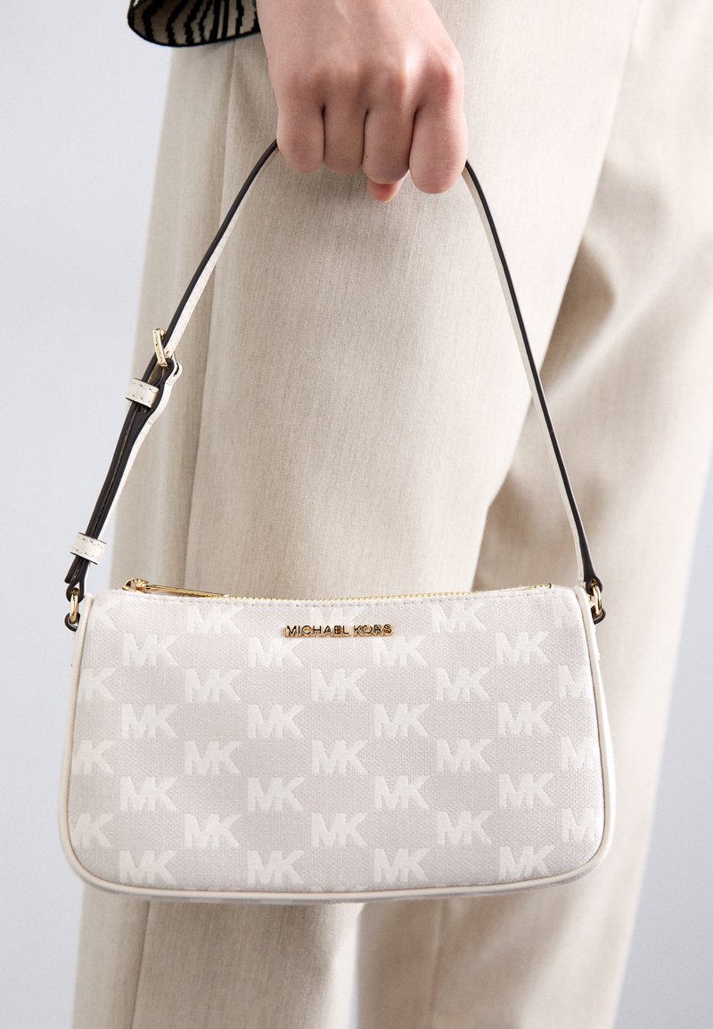 Borsa a tracolla bianca in tela con motivo MK discreto, cerniera dorata e tracolla regolabile marrone. Forma quadrata e texture liscia con dettaglio del logo.