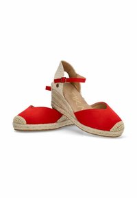 Alpargatas de lona rojas con cuña de yute trenzado, correa ajustable en el tobillo y diseño de punta cerrada con un acento texturizado en beige.