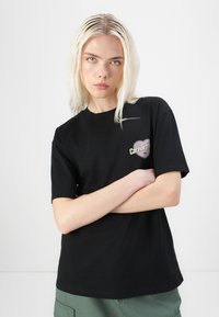 Black cotton t-shirt with short sleeves, featuring a heart-shaped logo in purple and white on the left chest area. Standard fit.