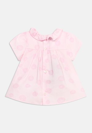 Robe rose pour bébé à manches courtes avec col froufroutant, patte de boutonnage à l'avant et motif circulaire subtil.