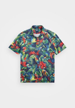 Polo a maniche corte blu navy con stampa tropicale di foglie verdi, fiori rossi e pappagalli colorati.