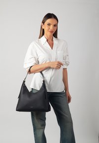 Black leather handbag with a smooth texture, hobo shape, and a top handle. Features subtle branding and gold-tone hardware accents.