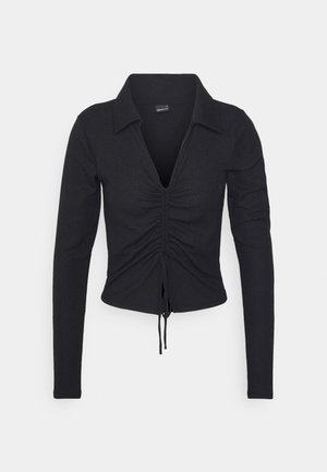 Czarna teksturowana bluzka z długim rękawem, kołnierzykiem, głębokim dekoltem w kształcie litery V oraz regulowanym marszczonym wiązaniem z przodu, dopasowany fason.