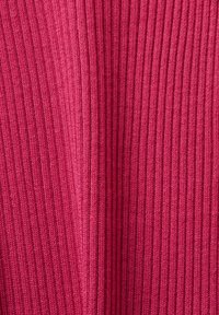 Tissu en tricot côtelé de couleur rose foncé, présentant des lignes verticales et une texture lisse. Le matériau est flexible et ajusté.