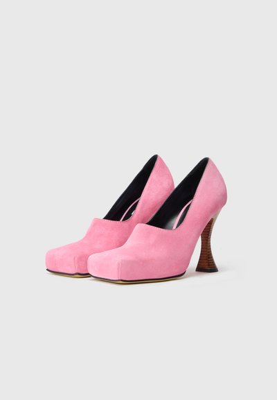 Rozā zamša augstpapēžu kurpes ar apaļu pirkstu un izliektu koka papēdi. Gluda tekstūra ar elegantu melnu iekšpusi un platformas zoli.