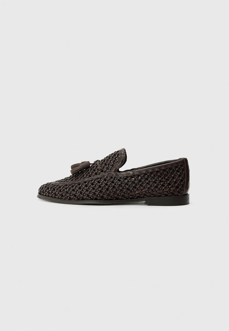 Brown woven slip-on shoe with a smooth leather accent and tassel detail, featuring a low profile and flexible sole.