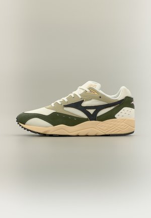 Nízký teniska s béžovými, olivově zelenými a černými panely, bílými šňůrkami a texturovanou pískově hnědou podrážkou na neutrálním pozadí.