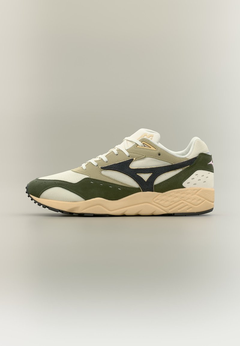 Lav sneaker med beige, olivengrønne og svarte paneler, hvite skolisser og en teksturert tan-såle mot en nøytral bakgrunn.