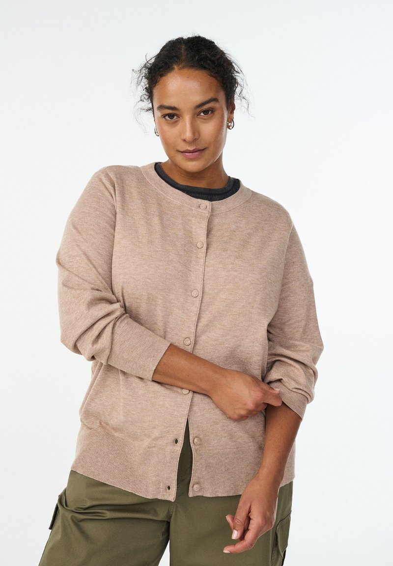 Helebeežitäpiline kardigan ümara kaelusega, pikkade varrukatega ja ees nööpidega kinnine. Pehme tekstuur ning soonilised mansetid ja alumine äär.