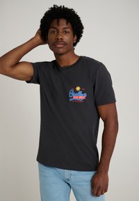 Black cotton t-shirt featuring a colorful graphic design with the text “Bradley’s BIG BUY,” short sleeves, and a standard fit.