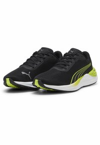 Zapatos deportivos negros con parte superior de malla, con un acento amarillo en el costado, una entresuela blanca y una suela exterior negra texturizada.