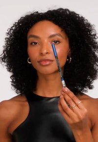 Blauwe eyelinerpotlood met een metalen zilverkleurige punt, vastgehouden door een persoon met krullend haar, met een gladde zwarte bovenkant en een strak ontwerp.