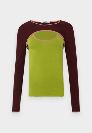 Majica z dolgimi rokavi, zelene barve telesa in bordočke barvnih rokavov, z izrezanim dizajnom in roza obrobo okoli izreza in roba izreza.