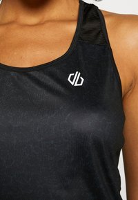 Zwarte sportieve tanktop met een gestructureerd patroon, voorzien van een ronde hals en een wit logo op de borst. Mengsel van stoffen voor comfort.
