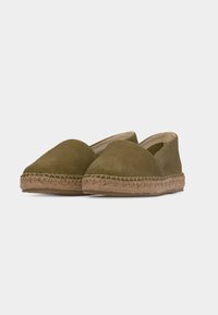 Paire d'espadrilles en daim vert olive avec semelles enveloppées de jute et bouts fermés arrondis, présentée sur un fond clair uni.