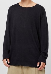 Czarna koszula z długim rękawem, szerokim dekoltem i luźnym krojem, wykonana z lekkiego materiału; posiada surowe wykończenie na dole i opadające ramiona.