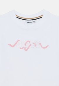Λευκό βαμβακερό T-shirt με στρογγυλή λαιμόκοψη, με ανοιχτό ροζ λογότυπο "BOSS" σε στιλιζαρισμένα γράμματα στο στήθος.
