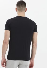 Mustat puuvillapaidat, pyöreä kaula-aukko, lyhyet hihat, slim fit -muotoilu. Sileä pinta, ei näkyviä kuvioita tai tarvikkeita. Takakatsaus esitetty.