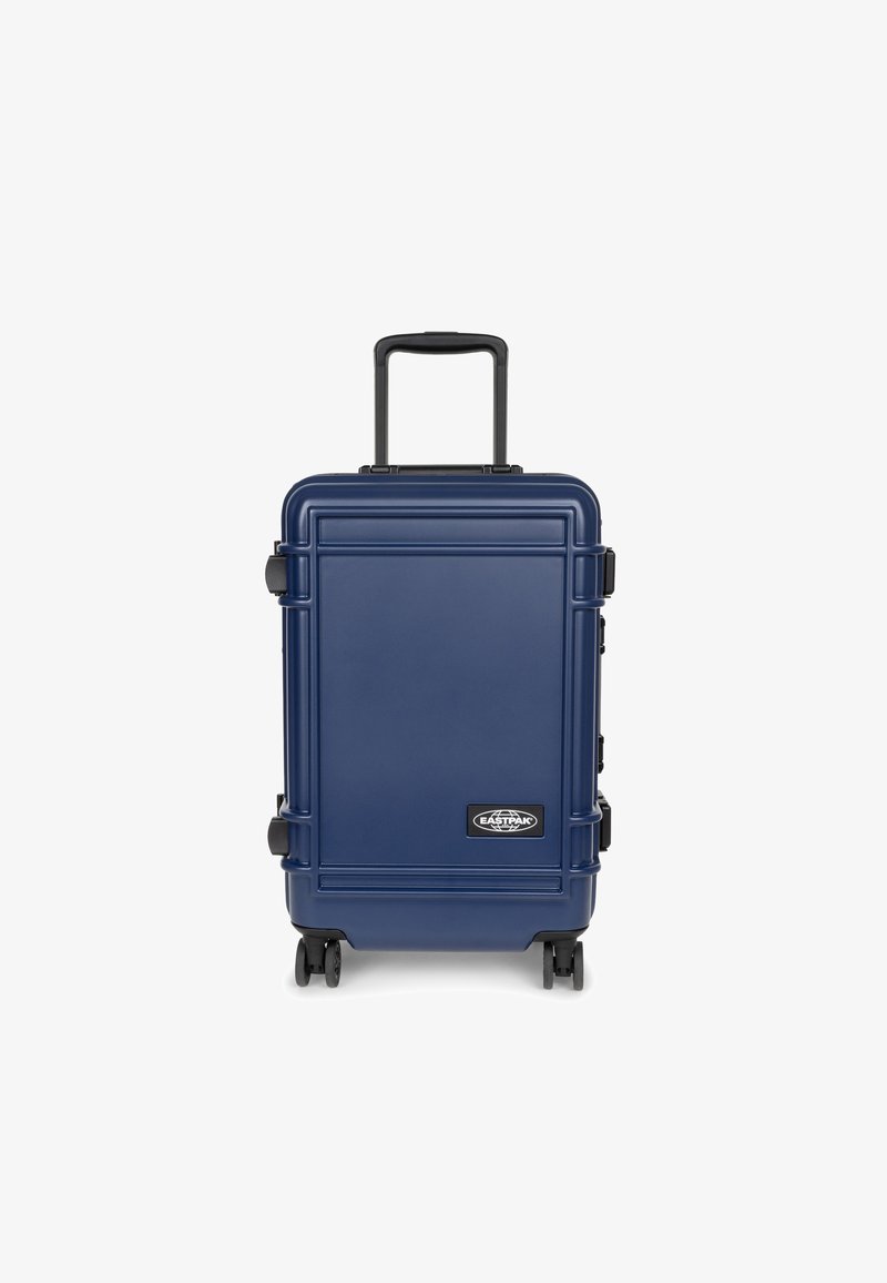 Námořnický tvrdý kufr s texturovaným povrchem, teleskopickou rukojetí a čtyřmi koly; má logo na přední straně a robustní zámky po stranách.