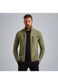 Olivno zeleni zip-up jopič z rebrasto teksturo, s stoje�čim ovratnikom in žepom na zadrgo. Ima prilegajočo obliko in stranske žepe.