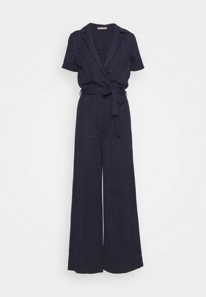 Combinaison bleu marine à manches courtes avec jambes larges, taille ceinturée et col en V avec revers.