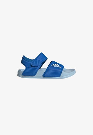 Zilas slaidu sandales ar regulējamiem siksnām, teksturētu augšdaļu, gumijas zoli un baltu Adidas logotipu. Izturīga konstrukcija ar ērtu piegulšanu.